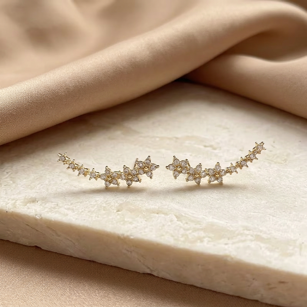 Gold-tone earrings styled on an ivory surface
