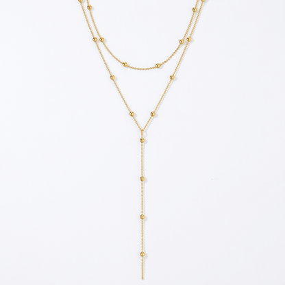Gold-tone layered necklace on white