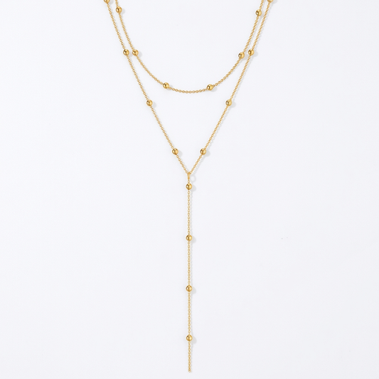 Gold-tone layered necklace on white