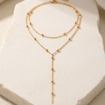 Gold-tone layered necklace styled on ivory stone